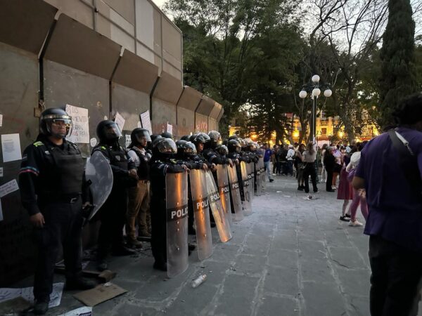 Chocan policías y feministas en Puebla: mujer es detenida; uniformados lanzan gas y agua