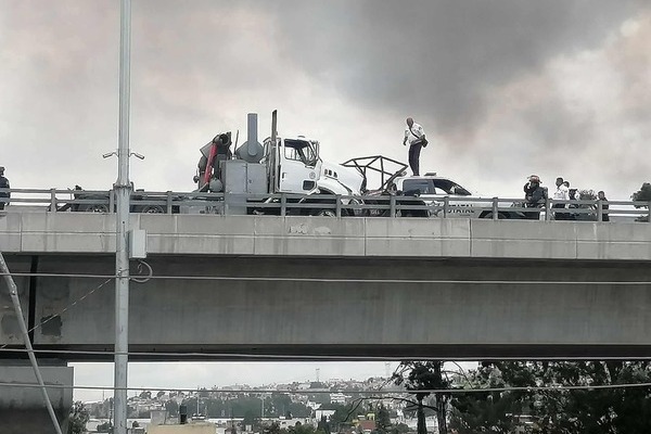 Derivado del choque, se registró un incendio en la parte alta de la autopista, y un contenedor que se desprendió cayó y aplastó una camioneta