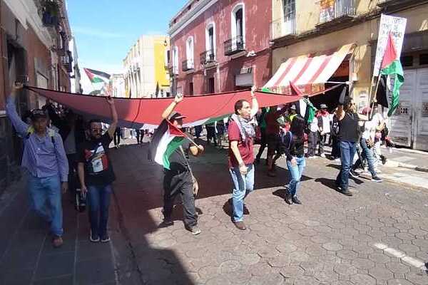 Al grito de "¡Los niños de Gaza no son una amenaza", participantes exhibieron una bandera monumental de Palestina frente a la CDH Puebla